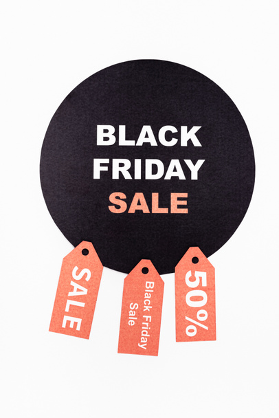 Vista superior del círculo negro con letras de viernes negro cerca de etiquetas de precios sobre fondo blanco - Foto, imagen