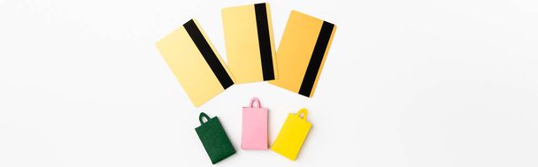 Foto panorámica de tarjetas de crédito y bolsas de compras de juguetes sobre fondo blanco - Foto, imagen