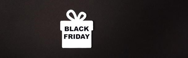Panoramic shot of paper gift box with black friday lettering on black background  - Photo, Image