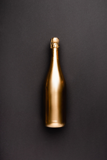 Widok z góry złotej butelki szampana na czarnym tle  - Zdjęcie, obraz