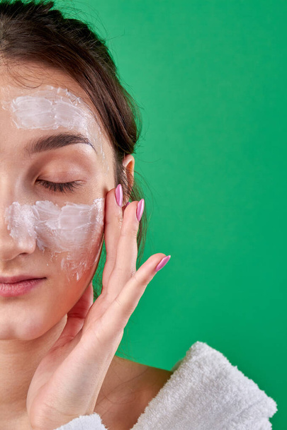Close-up young girl applying face mask. - Foto, Imagem