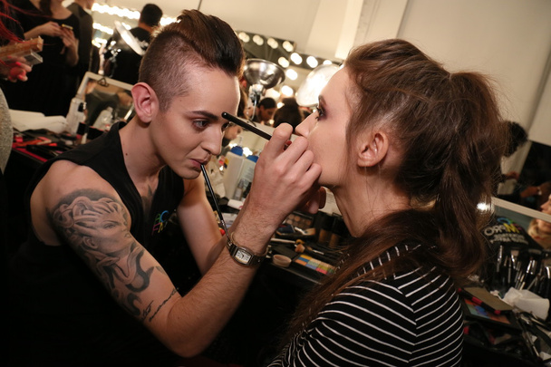 Make-up artist applying lipstick to model face - Photo, image