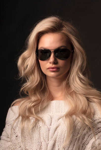 Blonde hair female mode in sunglassesl posing on camera  - Фото, изображение