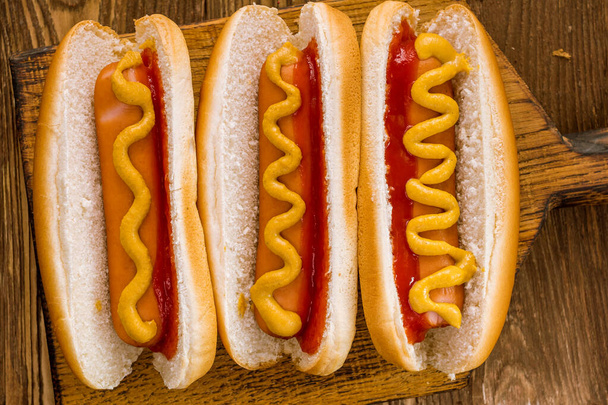 three classic hot dogs with ketchup and mustard - Foto, Imagen
