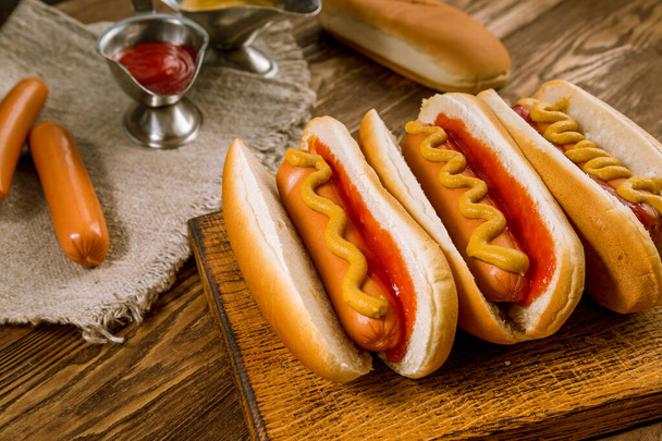 three classic hot dogs with ketchup and mustard - Фото, зображення