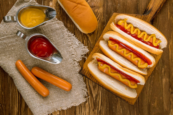 three classic hot dogs with ketchup and mustard - Foto, imagen