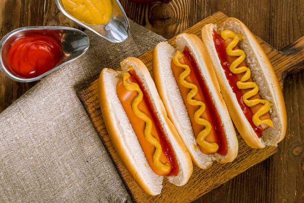 three classic hot dogs with ketchup and mustard - Foto, Imagen