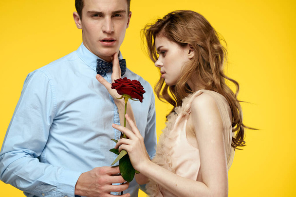 Enamored mężczyzna i kobieta z czerwoną różą na żółtym tle przycięte widok zbliżenie romans - Zdjęcie, obraz