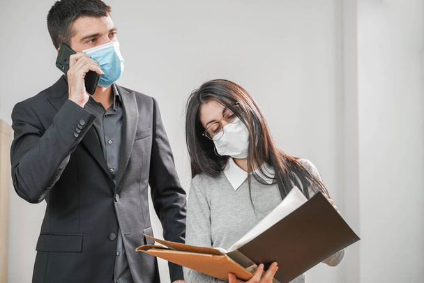 Coronavirus. Business workers wearing protective mask in a white background. Business workers with face masks back to work in office after lockdown. Small company concept. - Foto, imagen