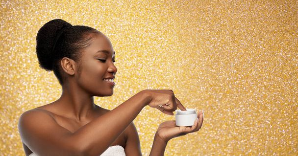 smiling african american woman with moisturizer - Foto, Imagem