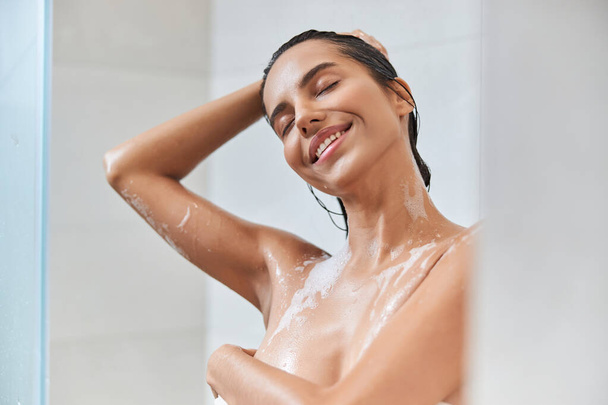 Attractive young woman washing her hair in shower - Photo, Image