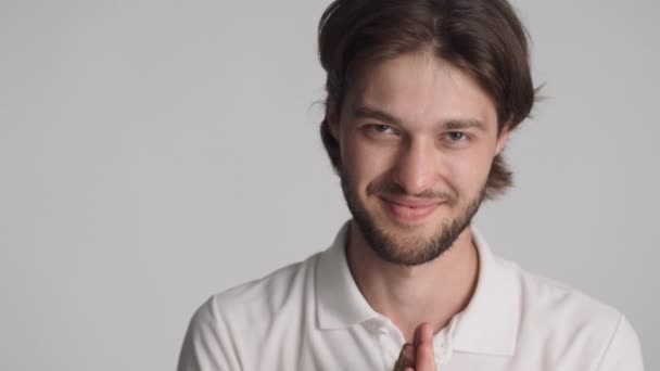Ritratto di attraente astuto ragazzo furbo sfregamento mani e sorridente sulla macchina fotografica su sfondo bianco - Filmati, video