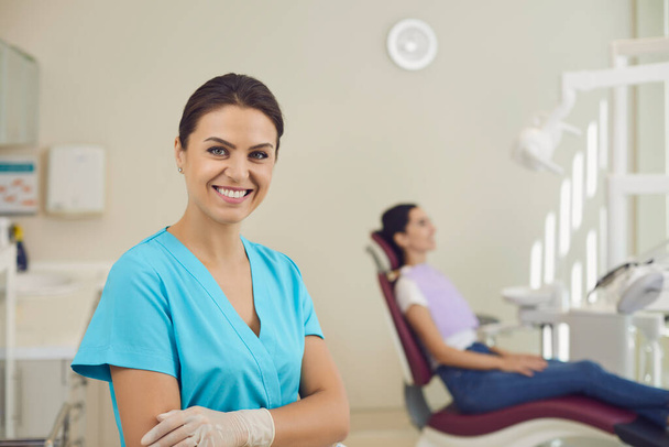 Vrouwelijke tandarts in een tandartspraktijk op de achtergrond van tandheelkundige accessoires. - Foto, afbeelding