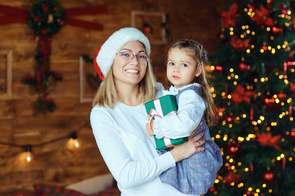 Mom with her daughter with gifts at Christmas. - 写真・画像