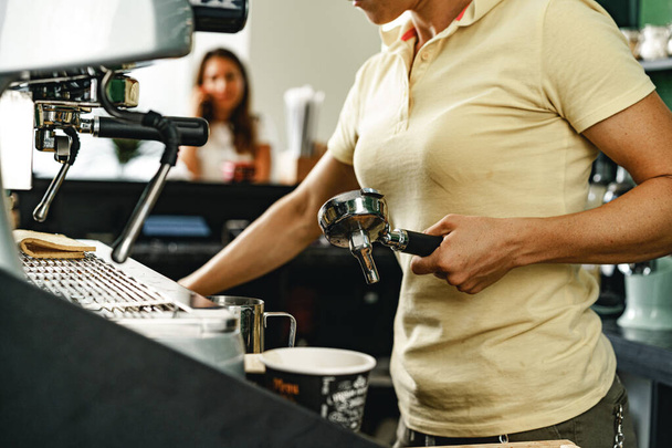Woman coffee shop worker preparing coffee on professional coffee machine - Foto, immagini