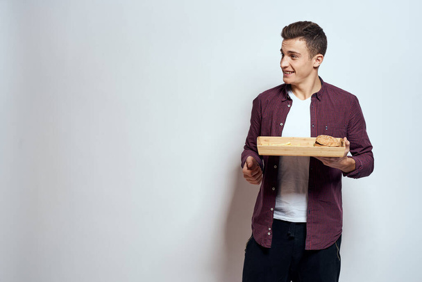 木製パレットを食べる男ファーストフードフライドハンバーガー食レストラン光の背景 - 写真・画像