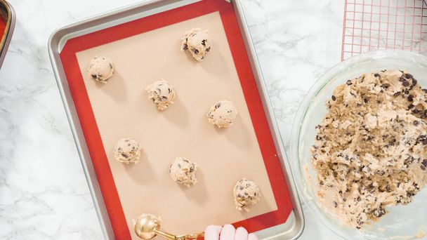 Step by step. Flat lay. Scooping homemade chocolate chip cookies with metal dough scoop to the baking sheet. - Photo, Image