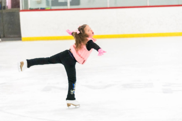 Küçük kız buz pistinde artistik patinaj yapıyor.. - Fotoğraf, Görsel