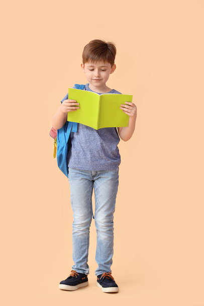 Little schoolboy with notebook on color background - Photo, Image