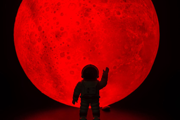 A silhueta do homem Astronauta. Há uma lua cheia vermelha no fundo. Conceito de horror Halloween. - Foto, Imagem