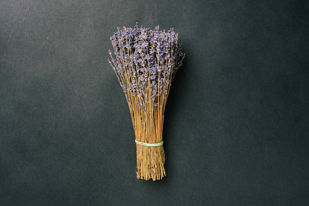Boeket droge lavendel op een zwarte achtergrond. gedroogde bloemen - Foto, afbeelding
