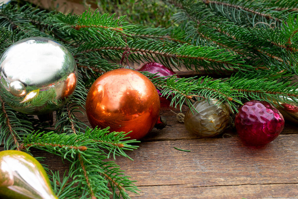 Christmas composition of Christmas tree decorations and spruce branches. Dark wooden texture background. Copyspace. New year flatly. - Fotoğraf, Görsel