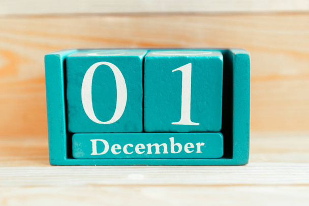 1er décembre. Calendrier cube bleu avec mois et date sur fond bois. - Photo, image