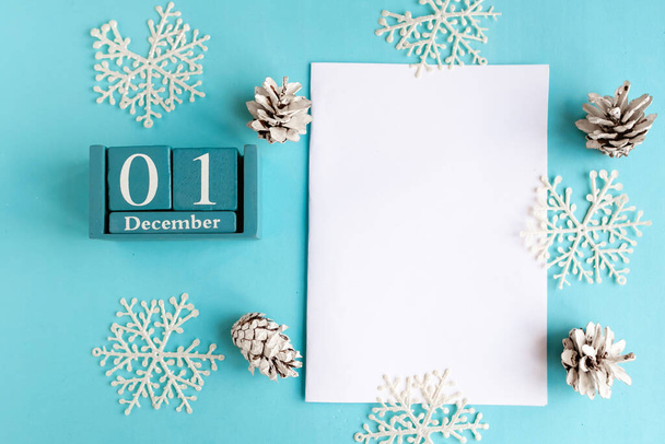 1. Dezember. Blauer Würfel-Kalender mit Monat und Datum und weißem Mockup-Rohling auf blauem Hintergrund. - Foto, Bild