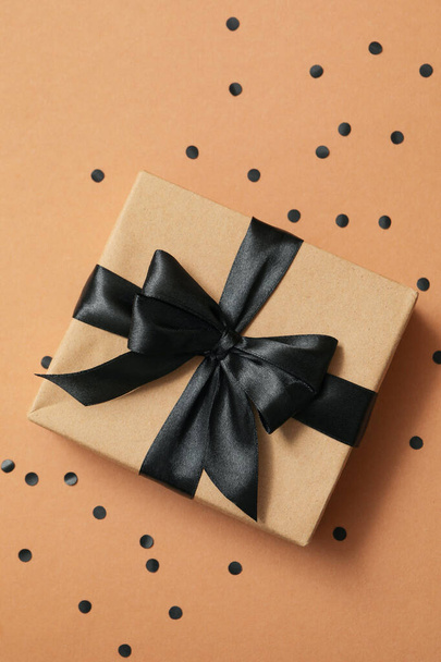 Caja de regalo con lazo negro sobre fondo artesanal - Foto, imagen