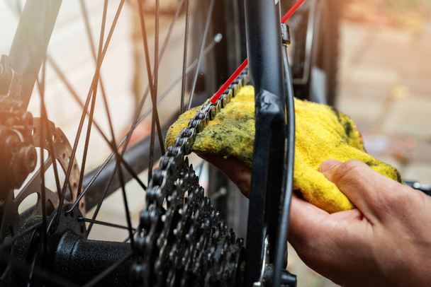 fiets onderhoud en reparatie - reinigen en oliën mountainbike ketting en versnelling met olie spray - Foto, afbeelding