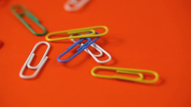 colored paper clips fall on the table. school supplies . paper clips close up - Footage, Video