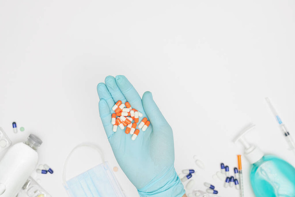 hand in glove with capsules on white background covid-19 coronavirus prevention concept flat lay - 写真・画像