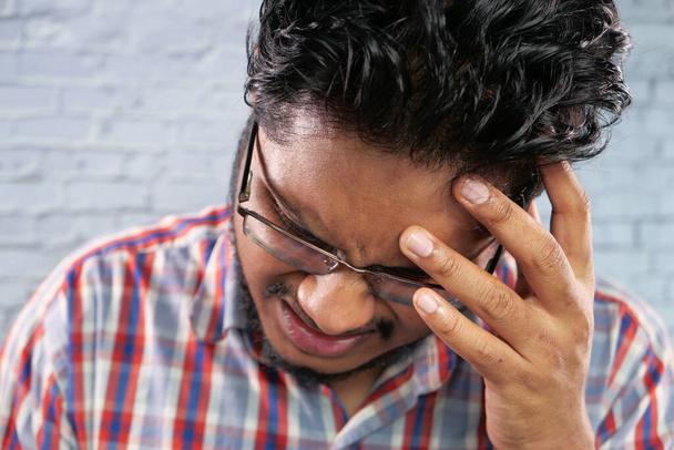 Junger Mann frustriert und mit Kopfschmerzen, aus nächster Nähe  - Foto, Bild