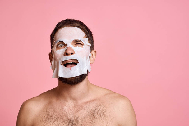 uomo in maschera detergente su sfondo rosa gesticolando con le mani nude torso vista ritagliata - Foto, immagini