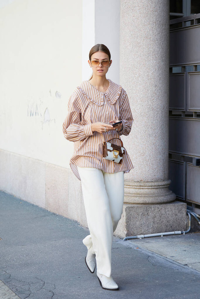 MILAN, ITALY - SEPTEMBER 26, 2020: Woman with brown and white striped shirt before Ports 1961 fashion show, Milan Fashion Week street style - Foto, afbeelding