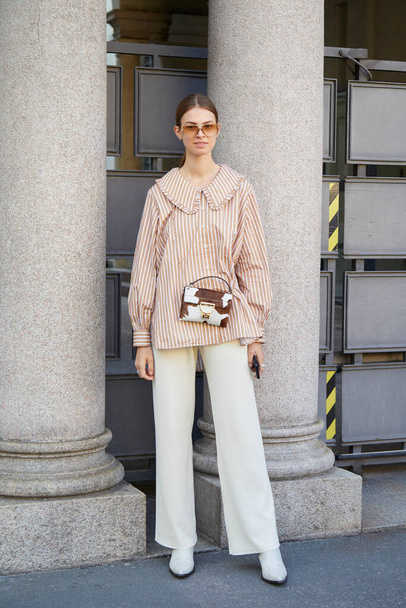 MILAN, ITALY - SEPTEMBER 26, 2020: Woman with brown and white striped shirt before Ports 1961 fashion show, Milan Fashion Week street style - Fotó, kép