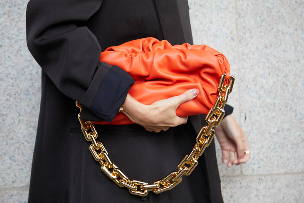 MILAN, ITALY - SEPTEMBER 25, 2020: Woman with orange leather bag and golden chain before Sportmax fashion show, Milan Fashion Week street style - Foto, Imagen