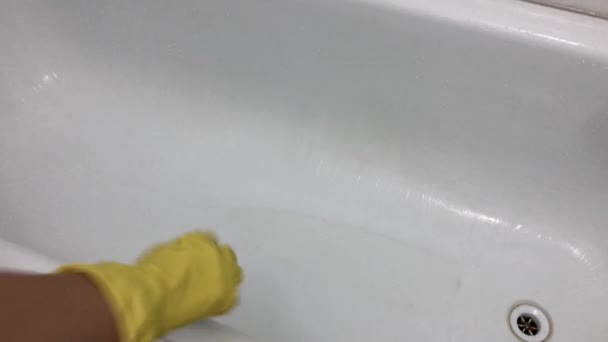 La mano en un guante amarillo de goma lava el baño con una esponja. - Imágenes, Vídeo