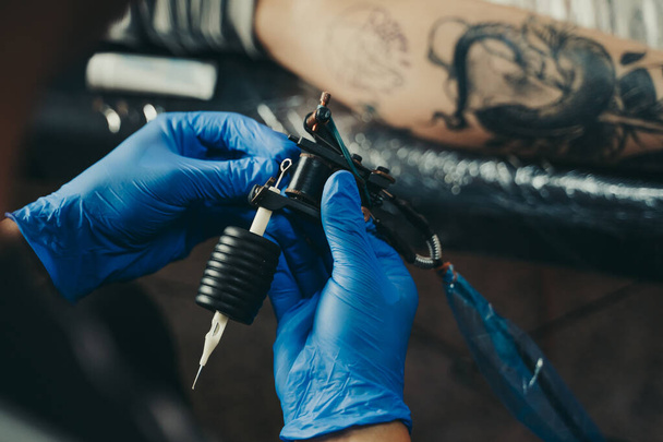 Професійний майстер татуювання вибирає голку на своїй машині в Іспанії.. - Фото, зображення