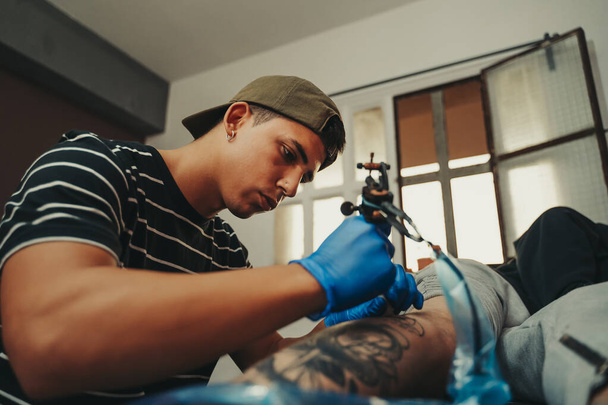 Jeune tatoueur travaillant dans son atelier professionnel à Barcelone, Espagne. - Photo, image