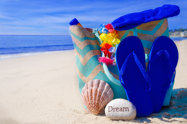 Bolsa de playa con chanclas junto al océano
 - Foto, Imagen