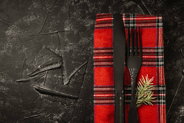  Black cutlery on red napkin and fir branch - minimalistic dark christmas background. High quality photo - 写真・画像