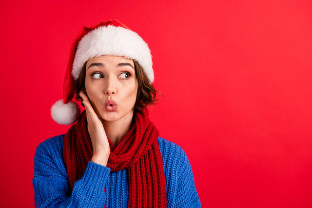 Omg christmas discount. Shocked girl in santa claus headwear lips pouted plump look copyspace impressed newyear news touch hand face wear sweater isolated bright shine color background - Foto, Imagen