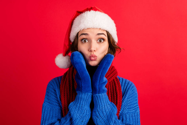 Photo of astonished girl in santa claus headwear touch hands gloves face lips pouted plump impressed magic miracle discounts wear jumper isolated over shine color background - Фото, зображення