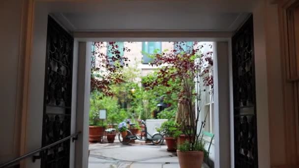 Hal leidt naar een tuin vol bloemen en planten - Video