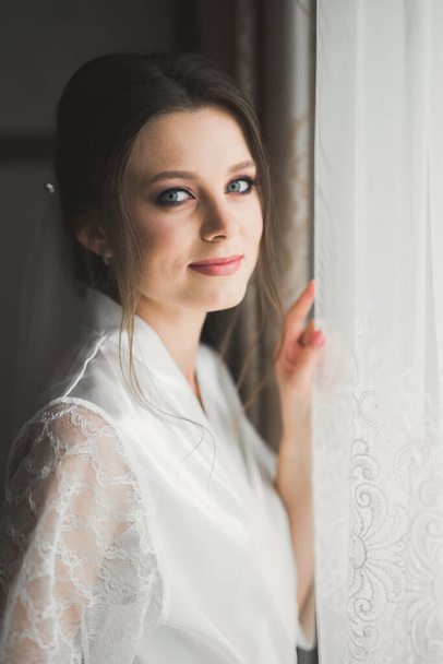 結婚式の準備中にポーズをとって白いドレスの豪華な花嫁 - 写真・画像