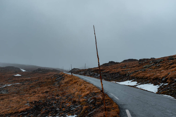 Rural road in Norway with overcast sky and vanishing point.  - Photo, Image