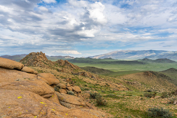 Yaz günlerinde Moğolistan 'daki Bayan Lake yakınlarındaki dağlarda yağmur bulutları ve tepeler arasında kayalık bir vadi var.. - Fotoğraf, Görsel