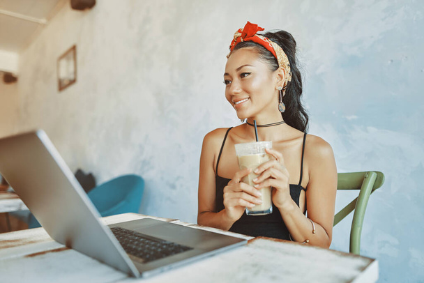 a young asian woman using laptop in cafe - Foto, imagen