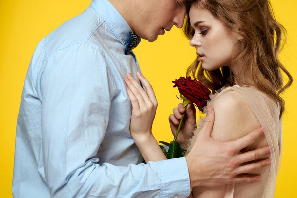 Enamored mężczyzna i kobieta z czerwoną różą na żółtym tle przycięte widok zbliżenie romans - Zdjęcie, obraz